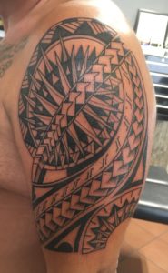 Grote Polynesische tribal tattoo op de bovenarm en schouder.