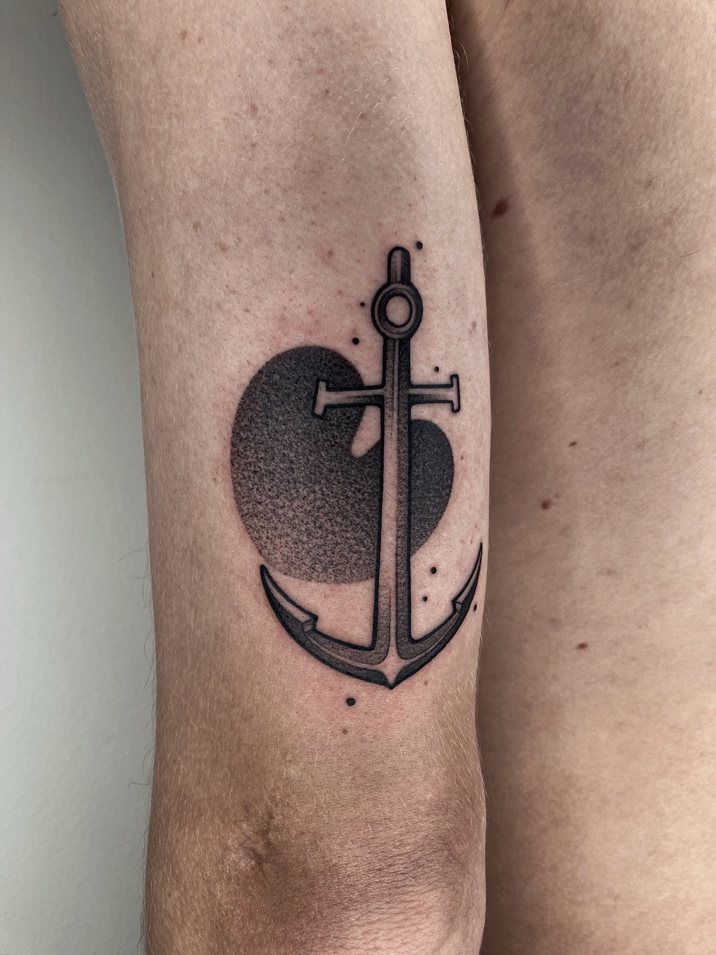 Anker met een hartvormige schaduw erachter, in dotwork en lijnwerk.