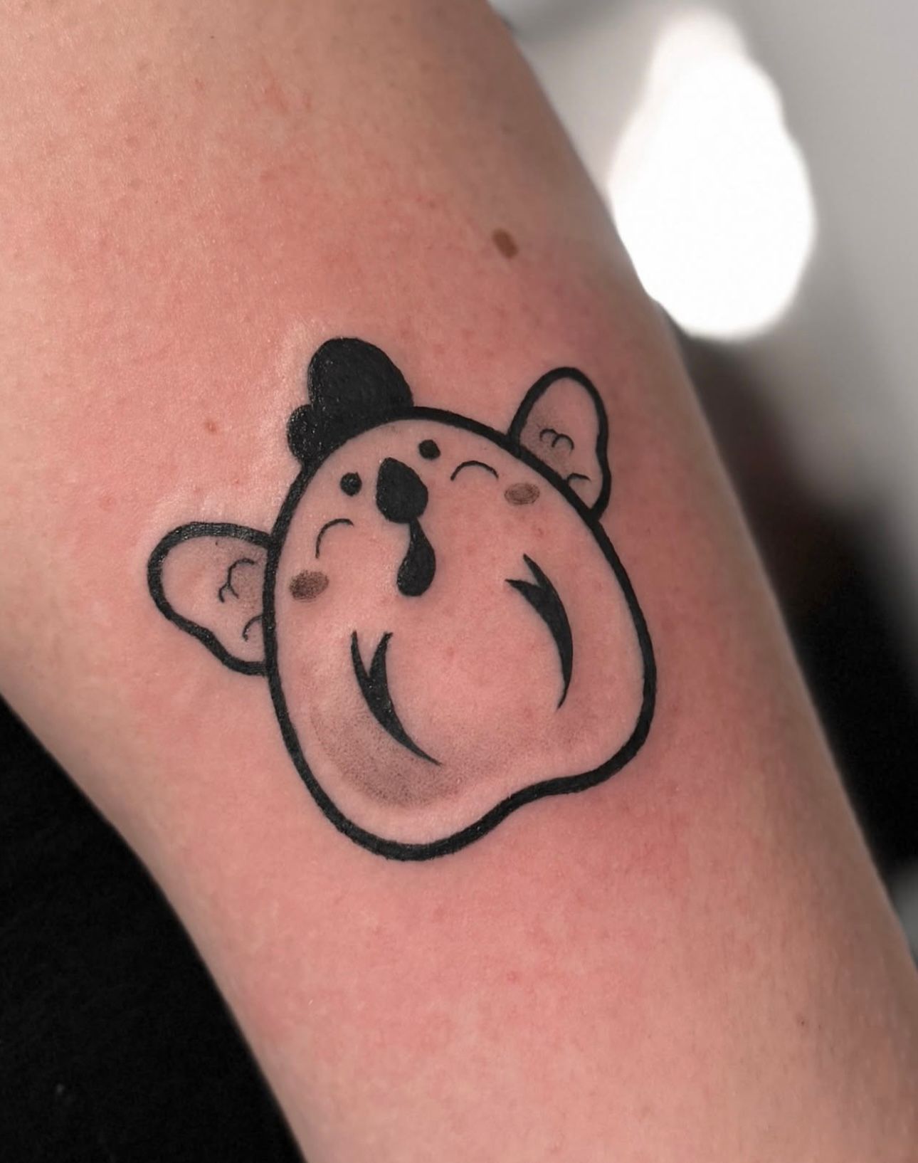 Schattige, minimalistische cartoon tattoo van een diertje met een hoedje.