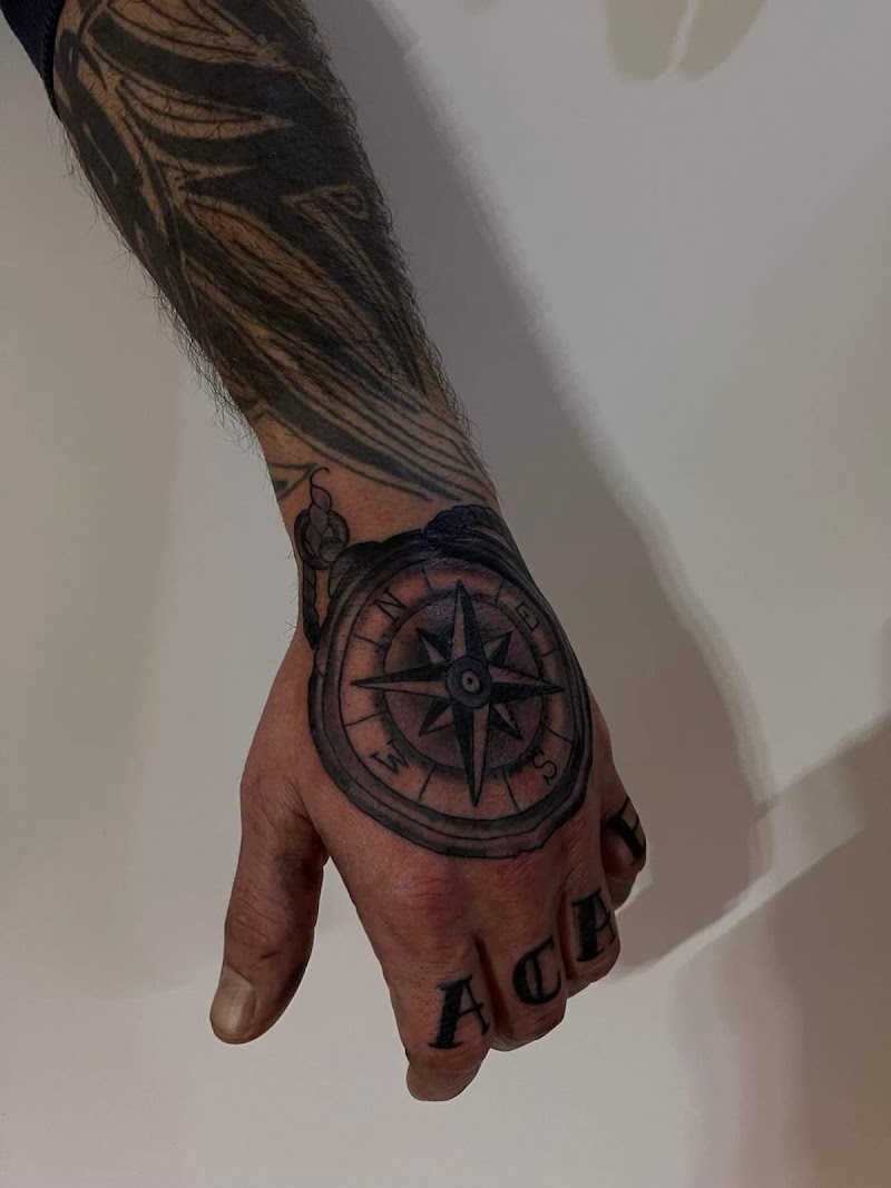 Zwart-wit kompas op hand en letters op vingers.