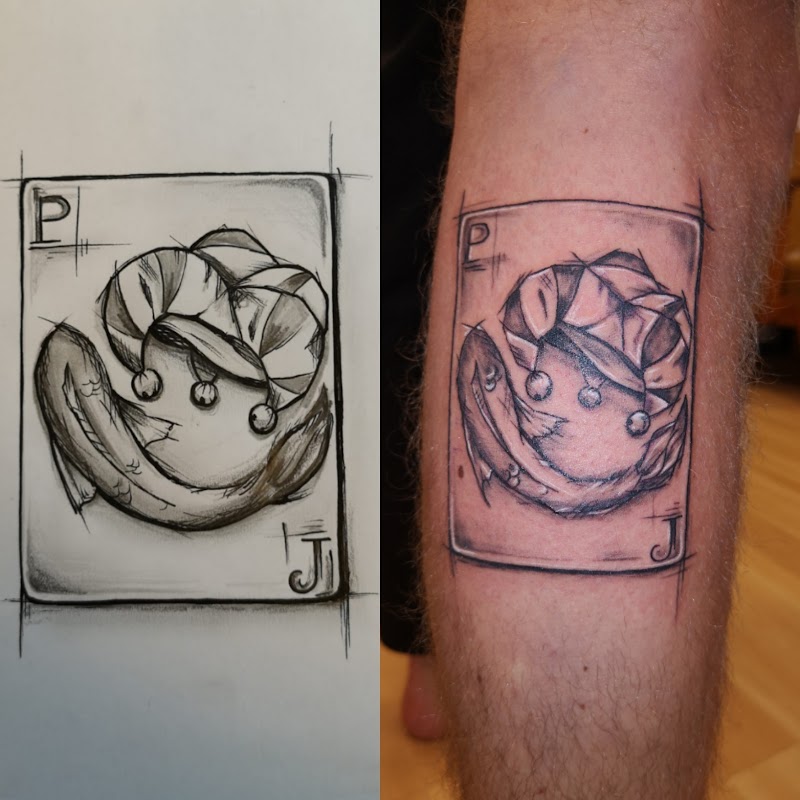 Schetsmatige speelkaart tattoo van een vis met een narrenmuts op het onderbeen.