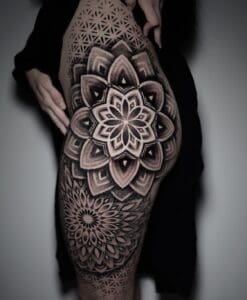 Grote geometrische mandala tattoo op bovenbeen en heup, dotwork stijl.