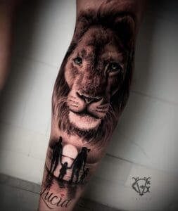 Realistische leeuwenkop met silhouet van gezin en naam 'Lucia' op onderbeen.