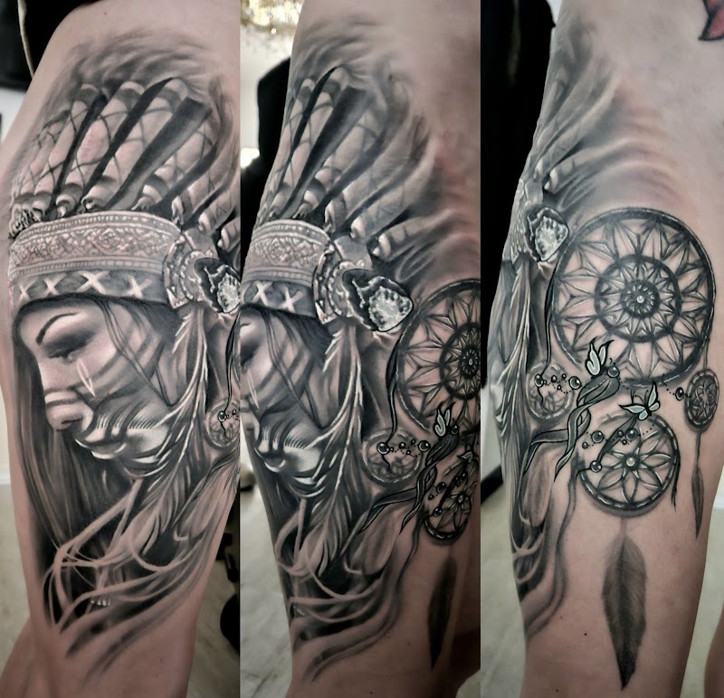 Realistische tattoo van inheemse vrouw met hoofdtooi en dromenvanger op bovenbeen.
