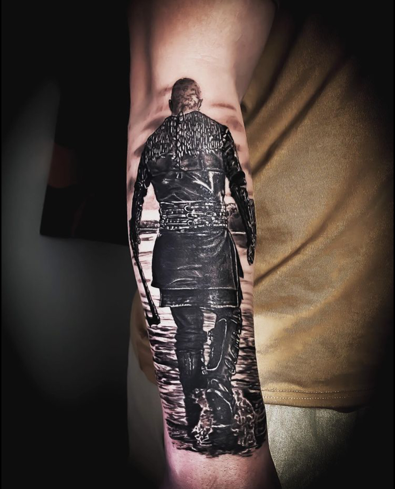 Realistische zwart-wit tattoo van een Viking krijger op de rug gezien.