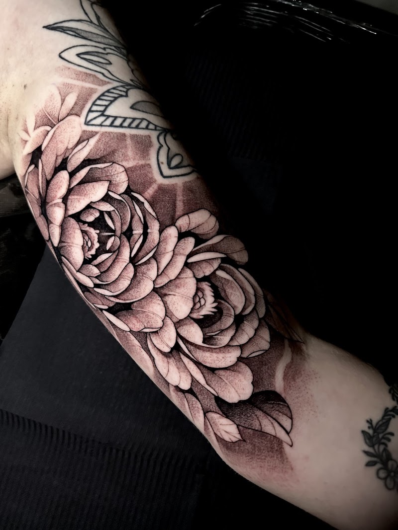 Blackwork pioenrozen tattoo op de onderarm.