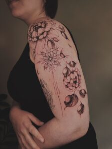 Fineline bloemen en mandala op bovenarm.