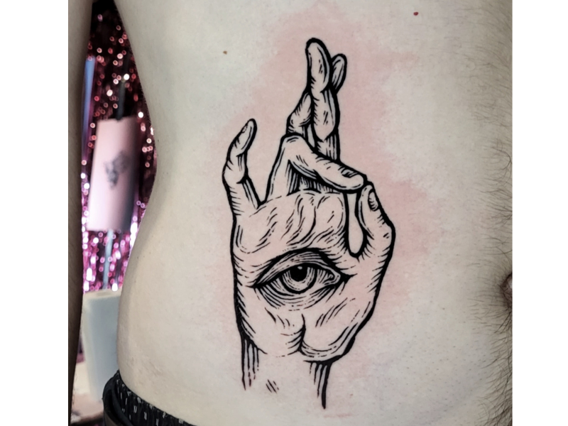 Illustratieve hand met oog en gekruiste vingers op de ribben.