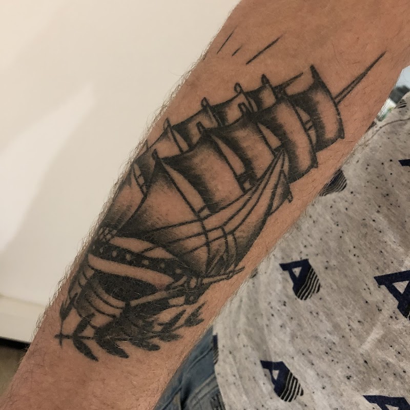 Zwart-wit traditioneel zeilschip met olijftakken op de onderarm.