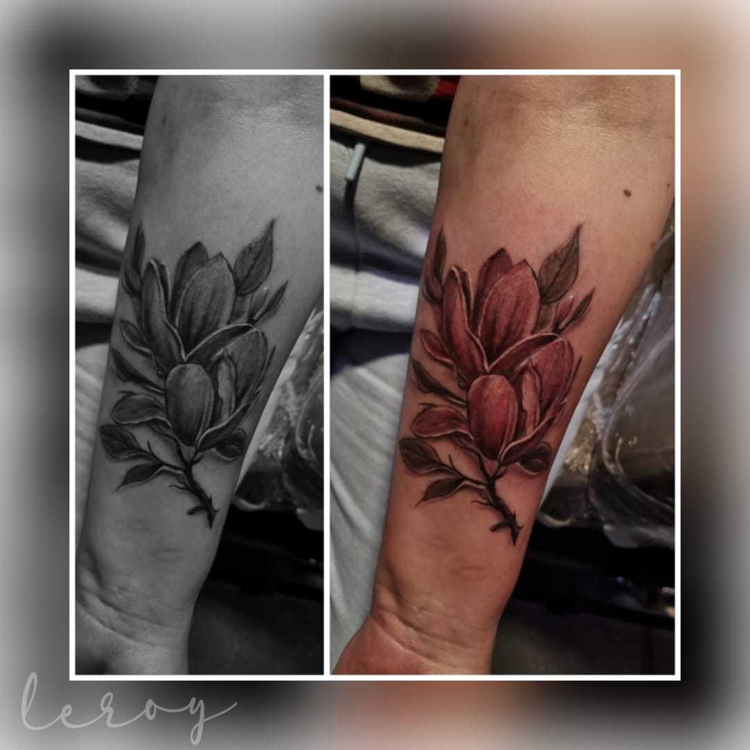 Realistische magnolia bloem tattoo op onderarm, getoond in kleur en zwart-wit.