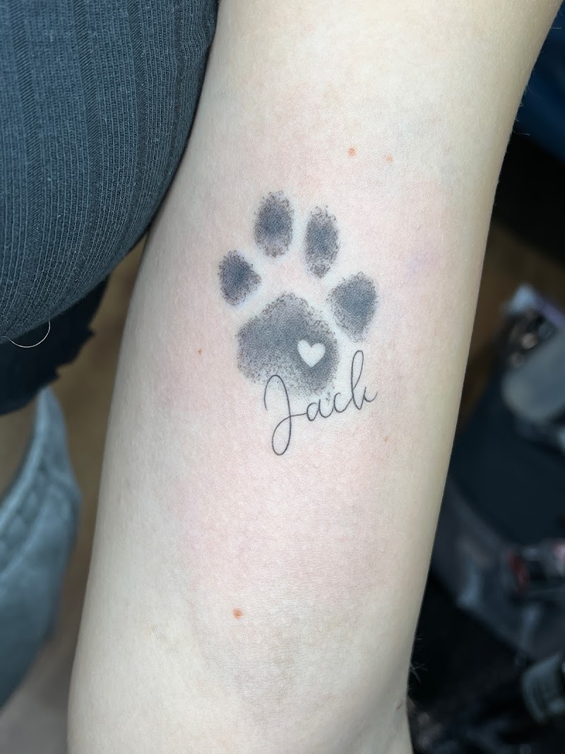 Fineline hondenpoot met hartje en naam 'Jack' op onderarm.