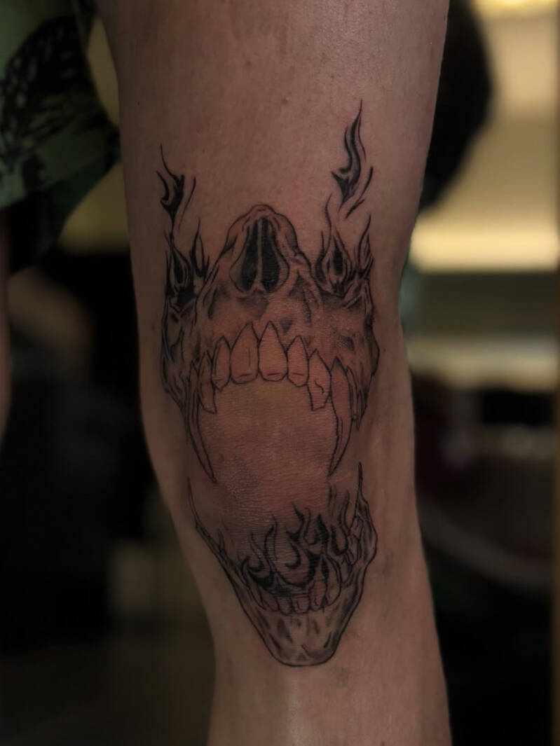 Zwart-wit schedel met vlammen op de knie.