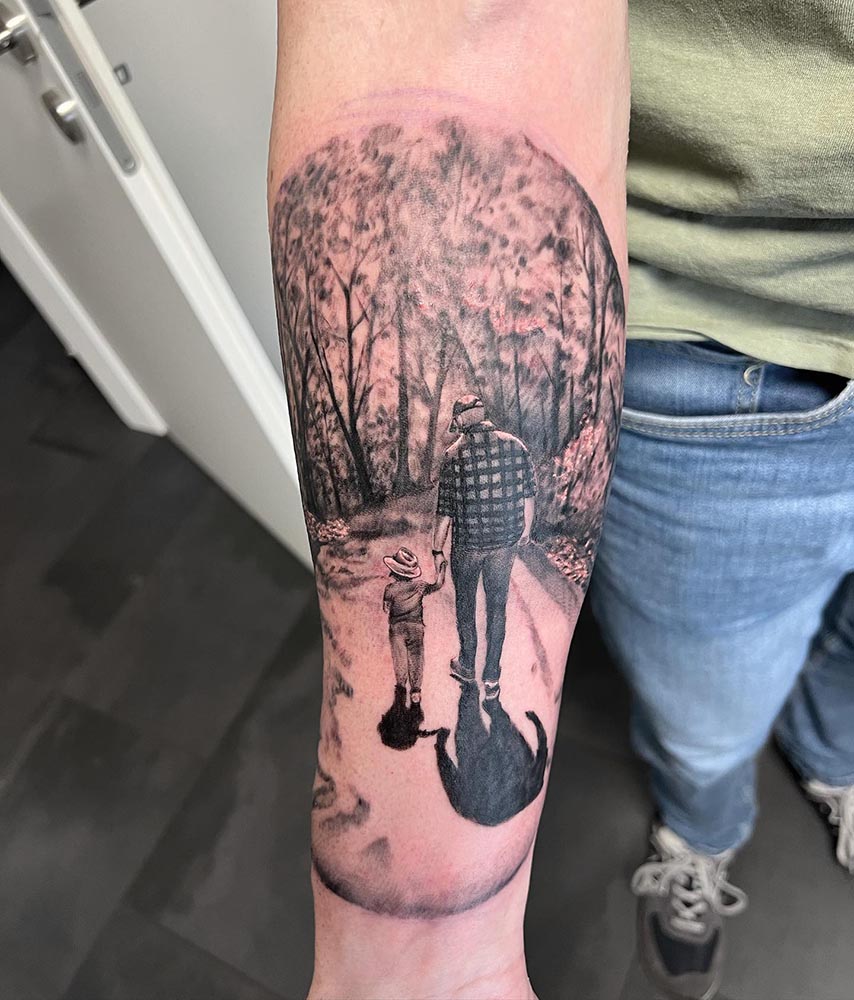 Realistische zwart-wit tattoo van vader en kind hand in hand in een bos.