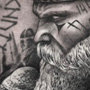 Realistische Viking portret tattoo met runen in zwart-wit.
