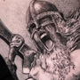 Realistische zwart-wit tattoo van een schreeuwende Viking krijger met helm en bijl.