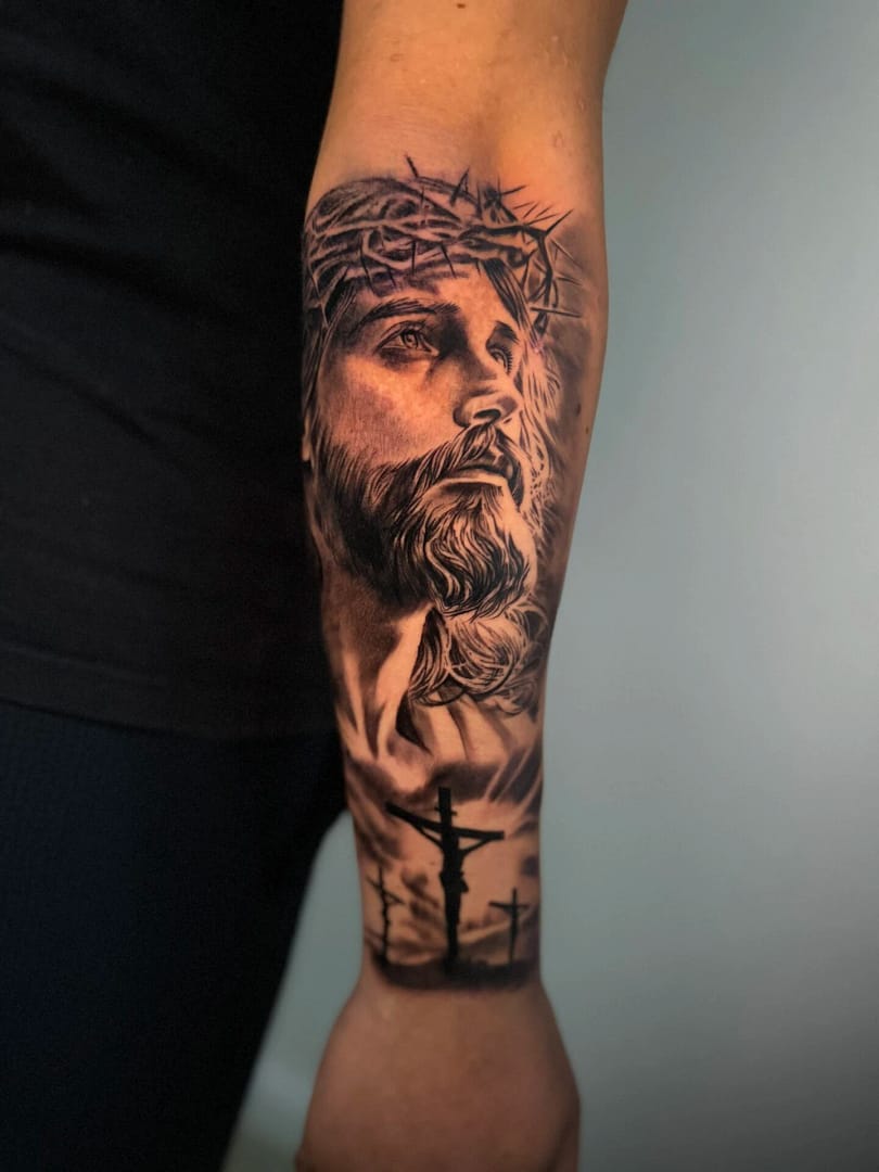 Realistisch portret van Jezus met doornenkroon en kruisen op de onderarm.