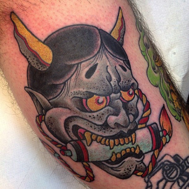 Traditionele Japanse Hannya masker tattoo met een rol in de mond.