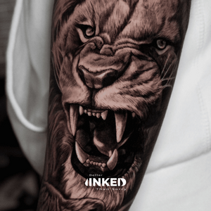Realistische brullende leeuw tattoo op de bovenarm.