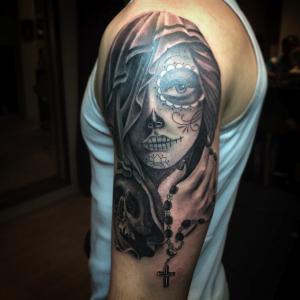 Realistische zwart-wit tattoo van een vrouw met suikerschedel make-up en rozenkrans.