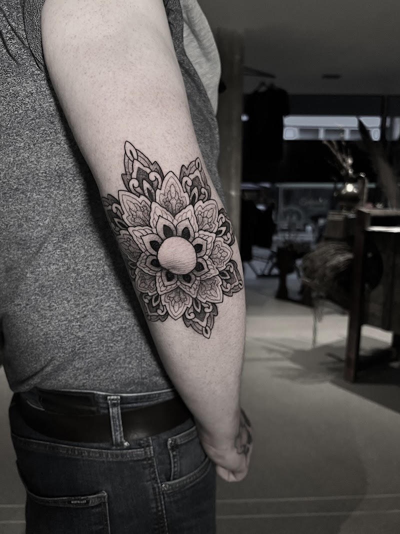 Gedetailleerde mandala tattoo op de elleboog.