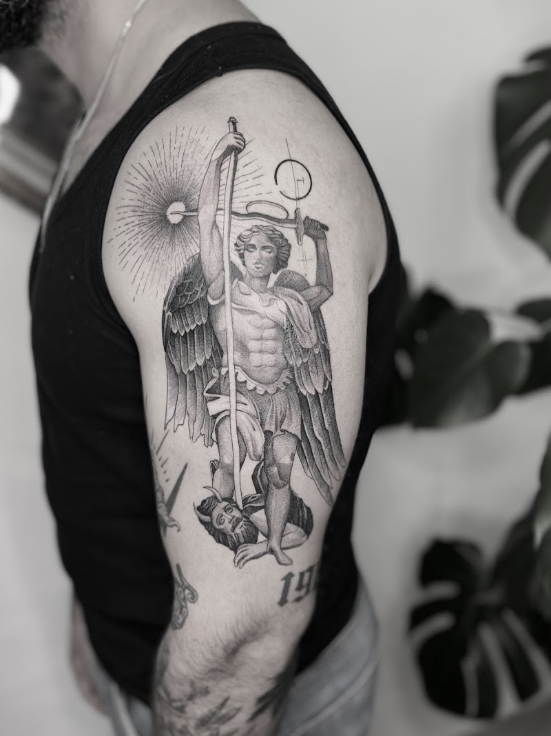 Gedetailleerde aartsengel Michaël die de duivel verslaat op bovenarm.