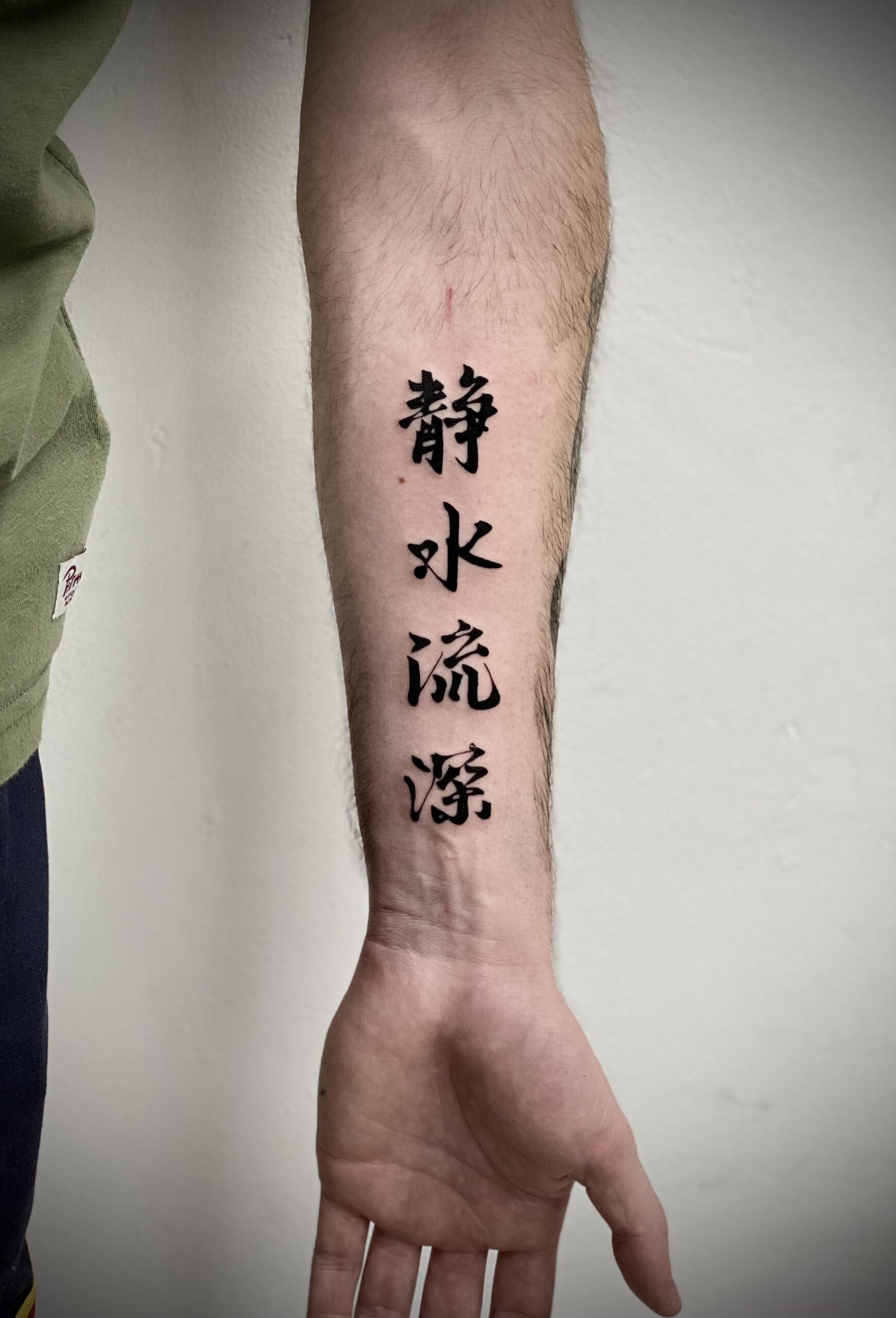Close-up van Chinese karakters op de onderarm.