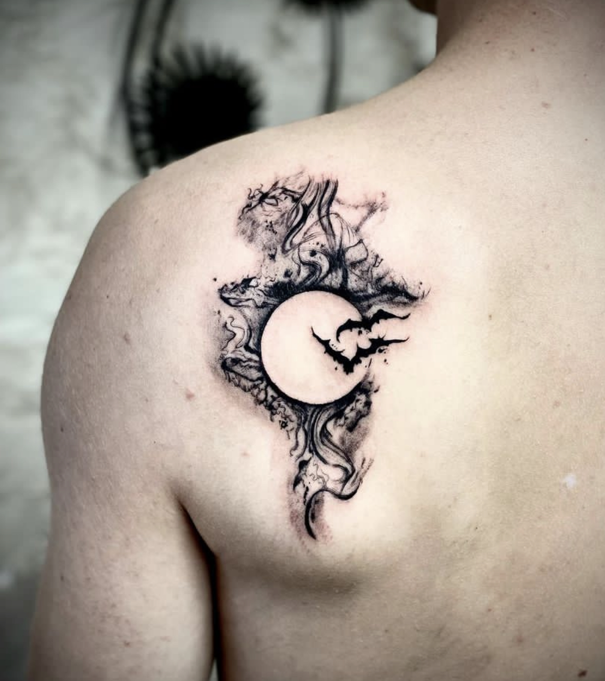 Maan met vleermuizen en abstracte rook op schouderblad.