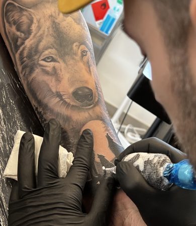 Realistische wolf tattoo in wording op onderarm.