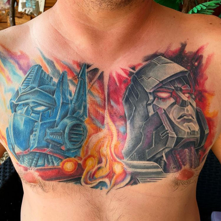Kleurrijke borsttattoo van Optimus Prime en Megatron uit Transformers.