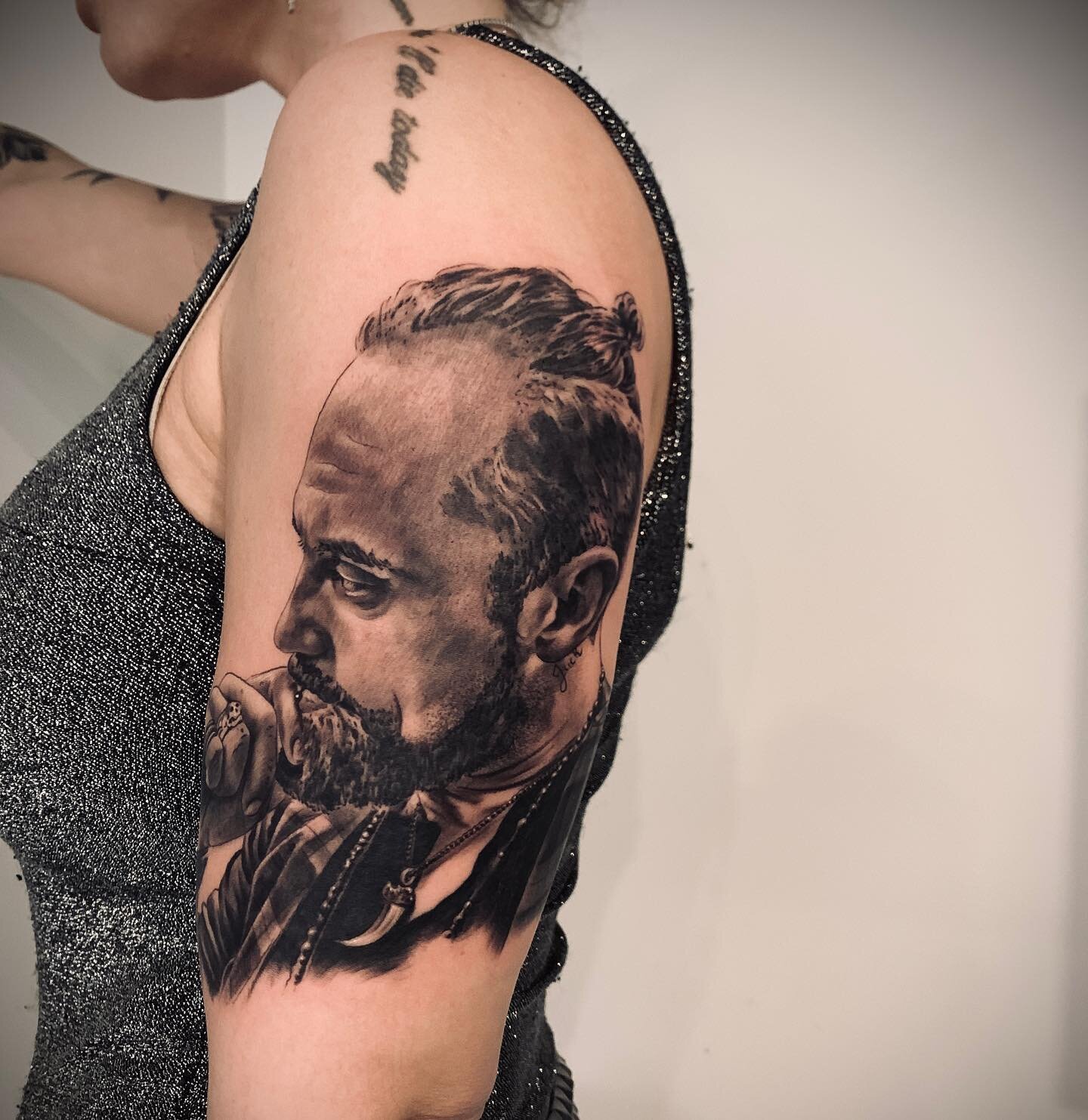 Realistisch portret van een man met baard en knot op de bovenarm.