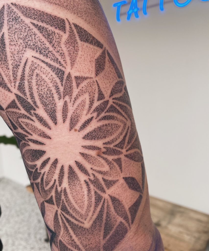 Grote dotwork mandala tattoo op de bovenarm.