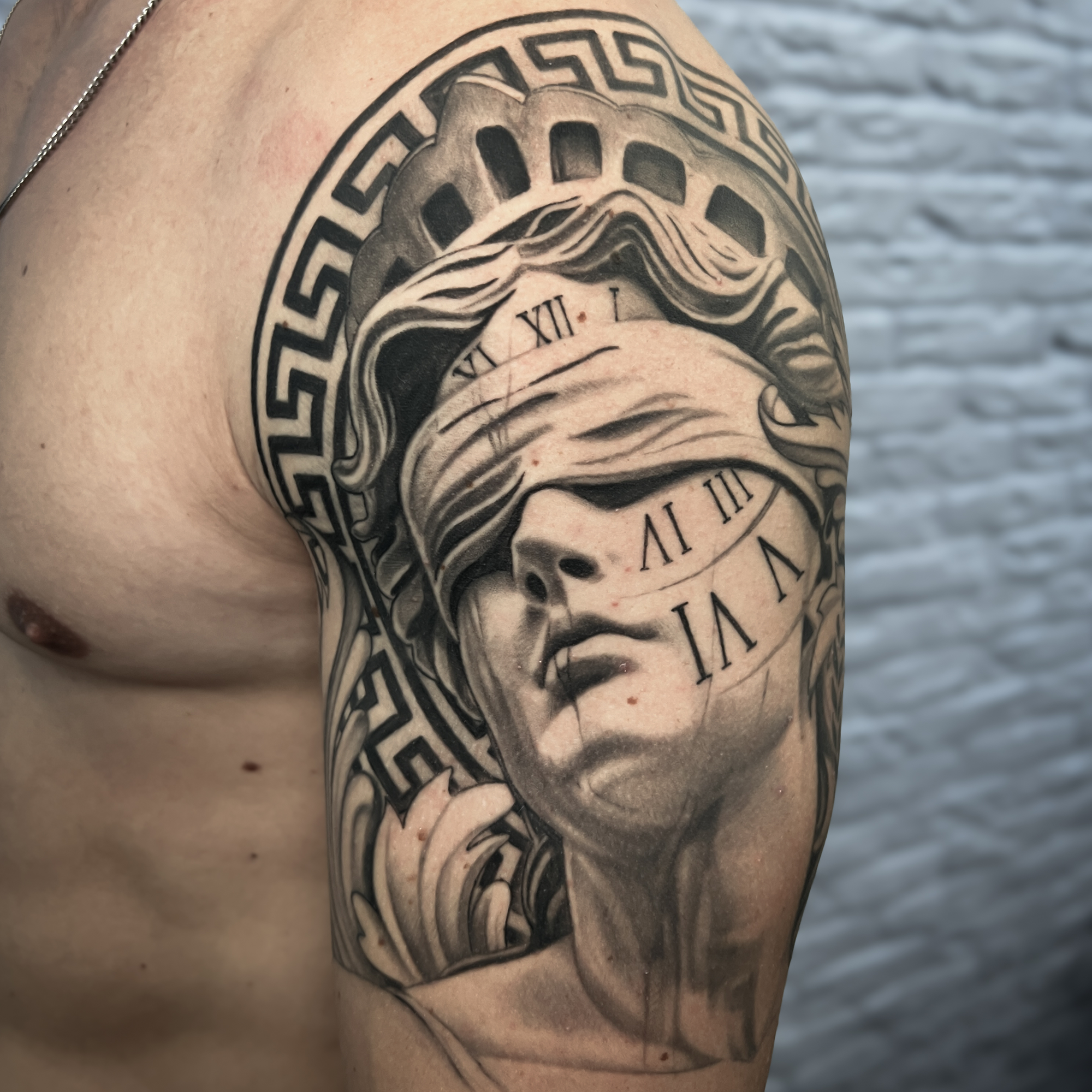 Realistische Vrouwe Justitia met blinddoek en klok op bovenarm.