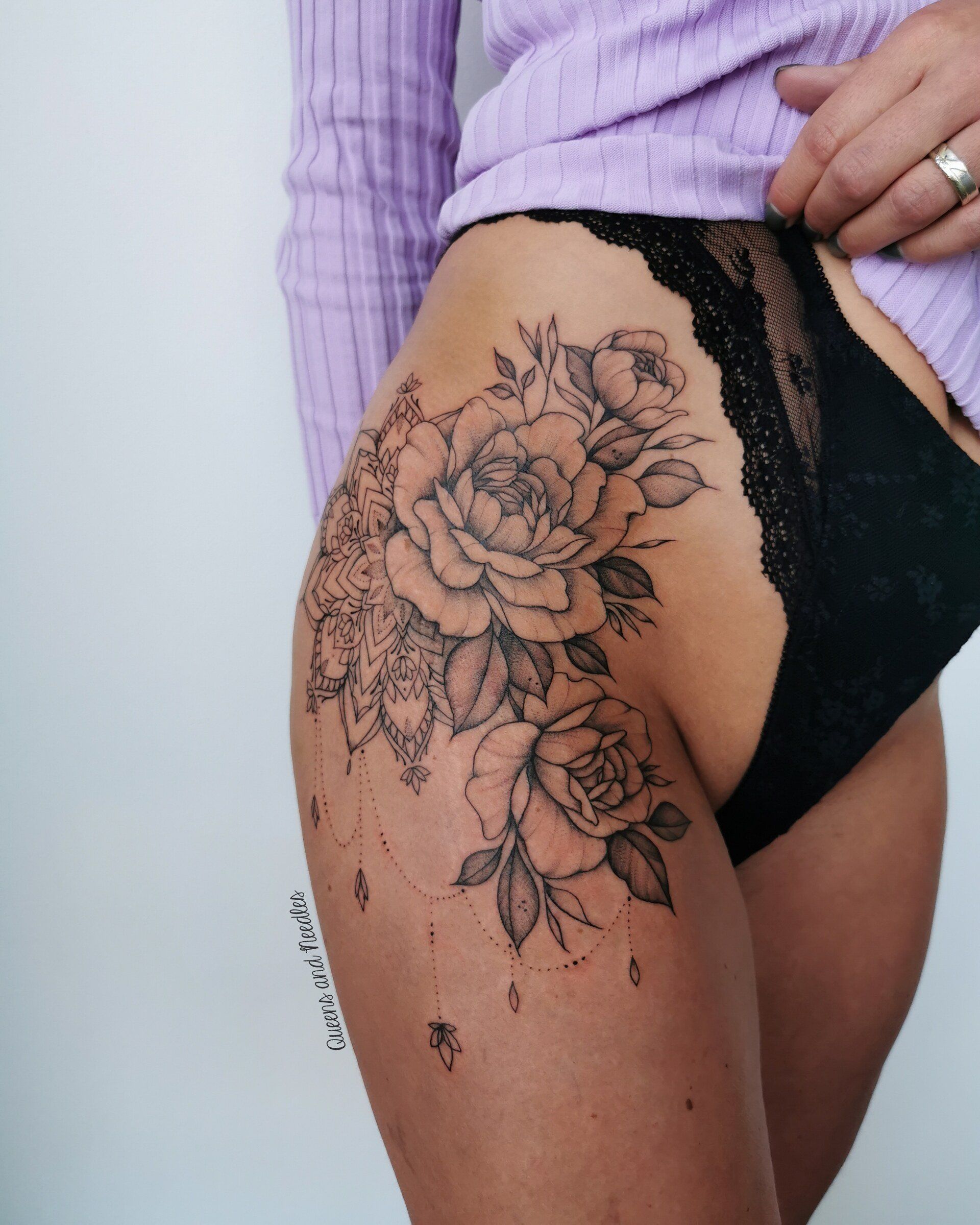 Grote bloemen en mandala tattoo op de heup en bovenbeen.