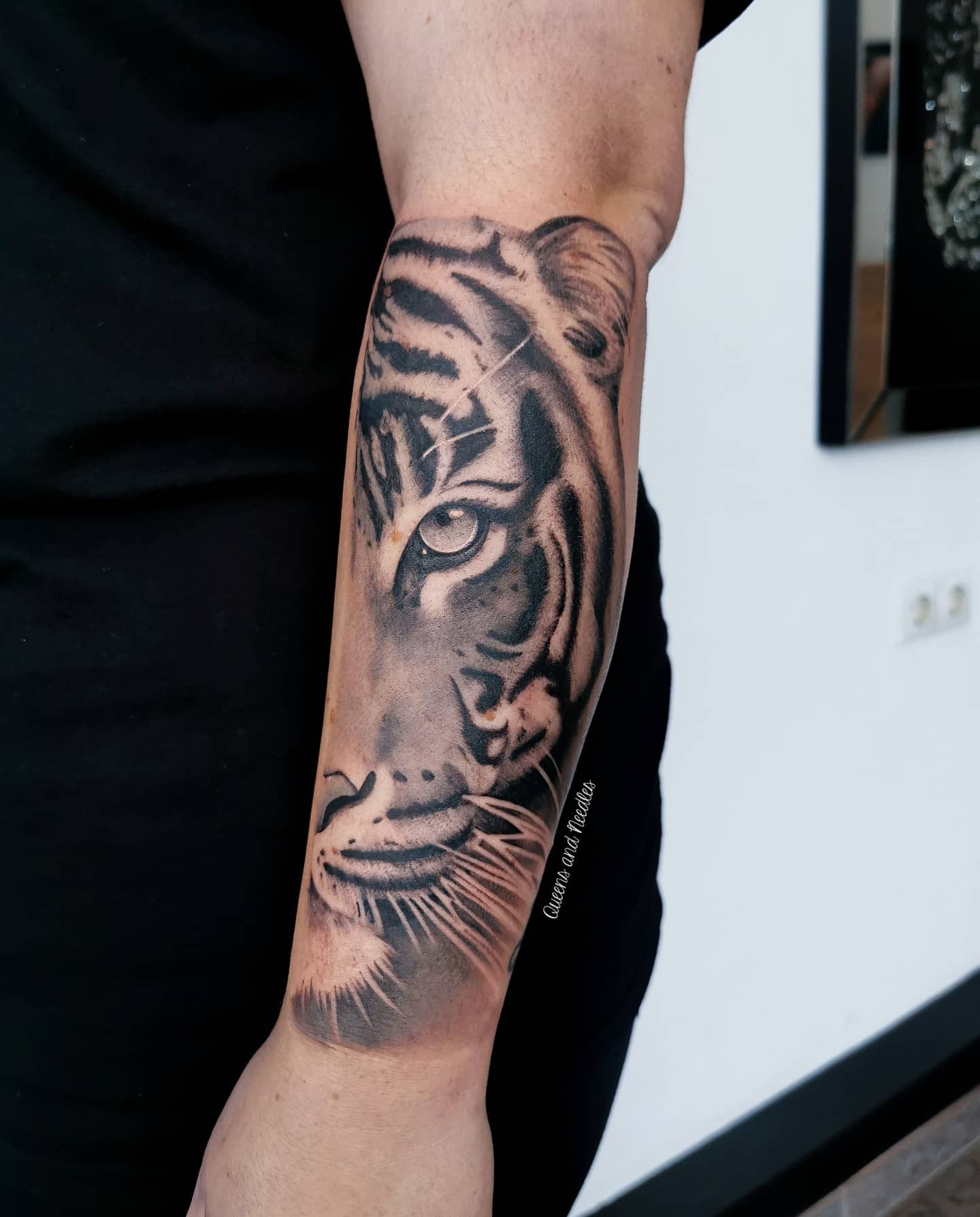 Realistische zwart-wit tijgerkop op onderarm.