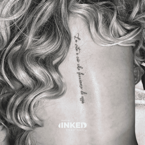 Fineline tekst tattoo op de ruggengraat.