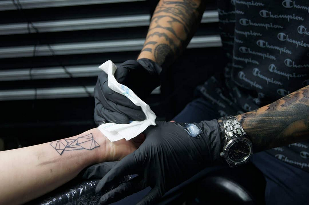 Geometrische lijnwerk tattoo op de pols, net gezet.