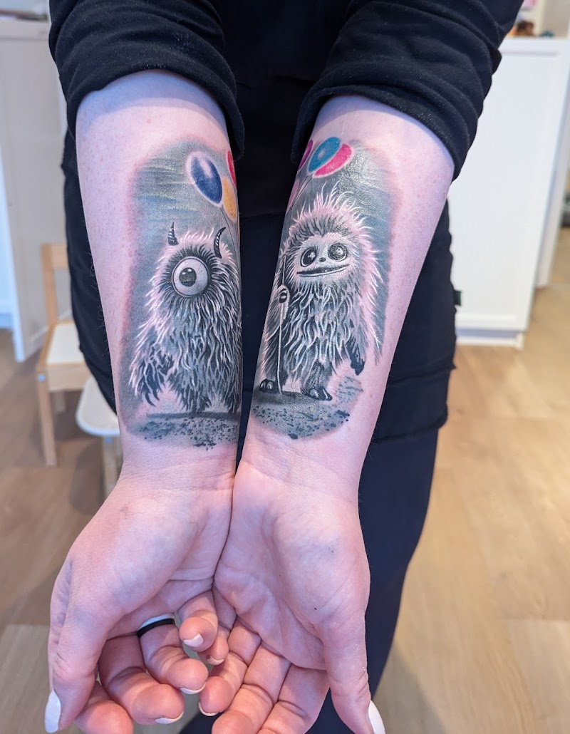 Twee schattige, harige monsters met ballonnen op beide onderarmen.