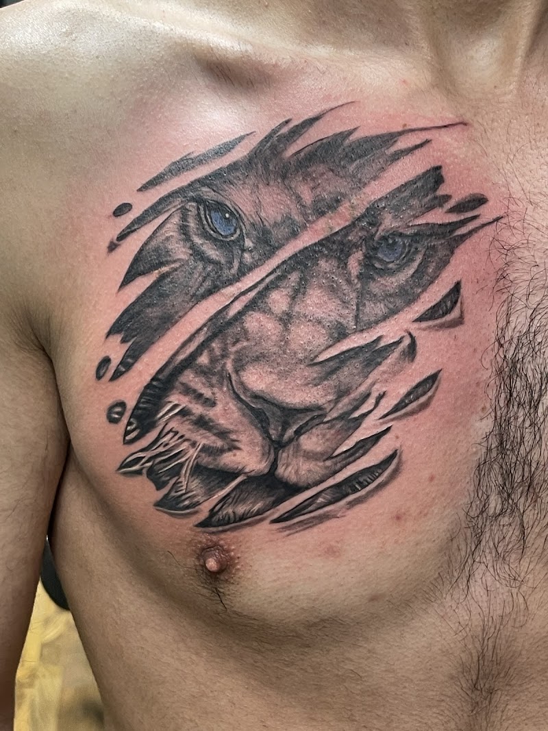 Realistische leeuwenkop die door de huid breekt op de borst.