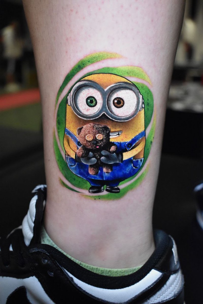 Kleurrijke Minion met teddybeer tattoo op enkel.