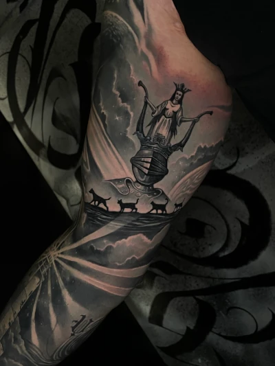 Blackwork tattoo van een vrouw in een kelk met katten en een nachtelijke lucht.