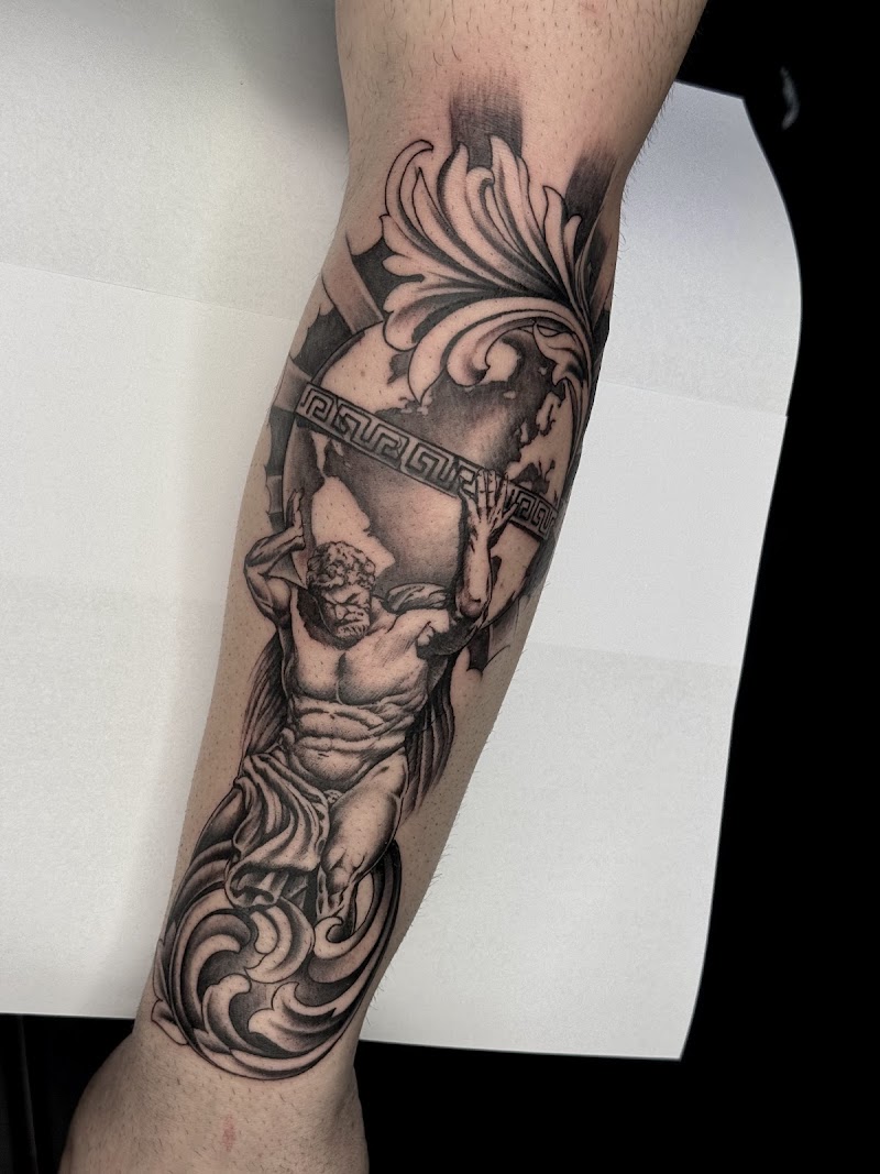 Blackwork tattoo van Atlas die de wereldbol draagt op het onderbeen.