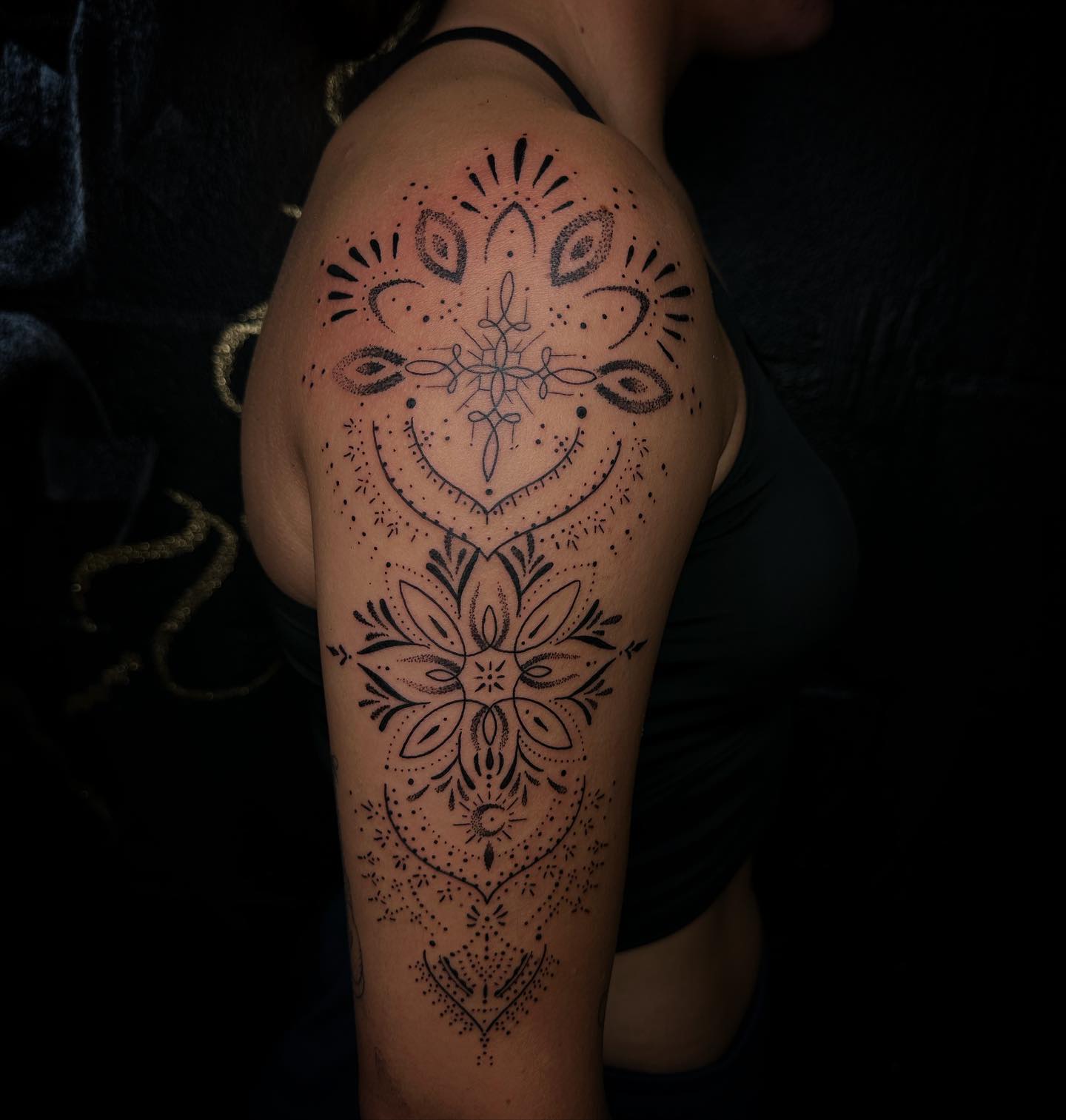 Grote ornamentale mandala tattoo met dotwork op schouder en bovenarm.