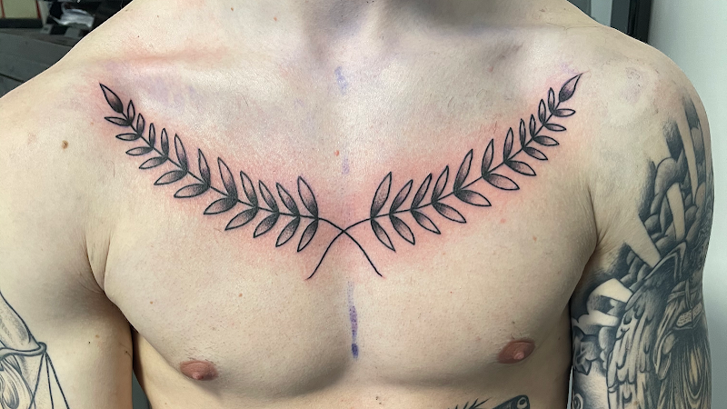 Zwart-wit lauwerkrans tattoo op de borst.