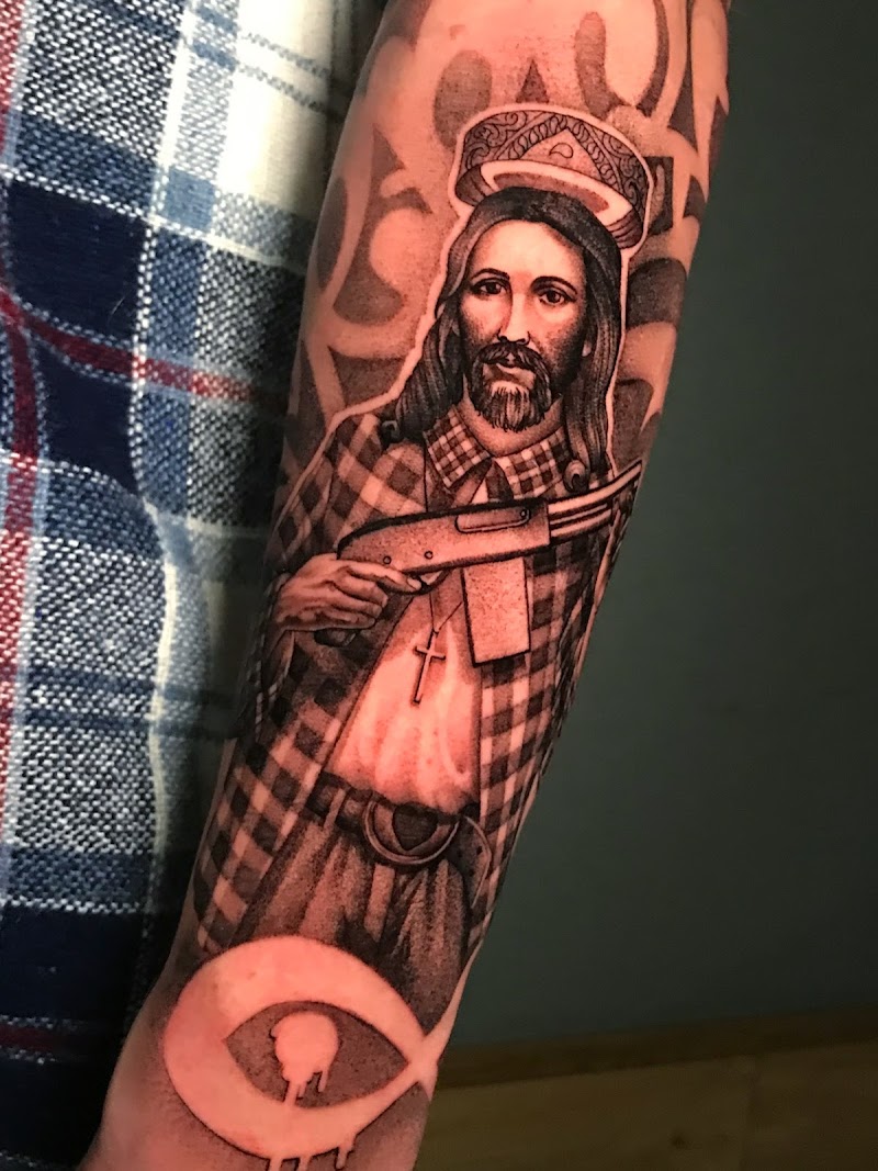 Blackwork tattoo van Jezus met een geweer en een vissymbool.