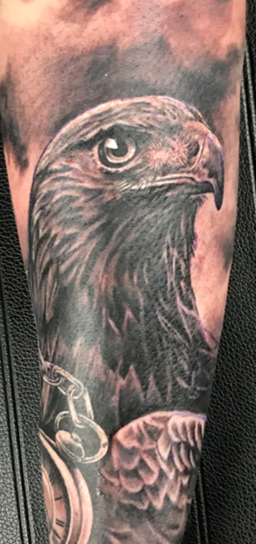 Realistische adelaar en zakhorloge tattoo op arm.