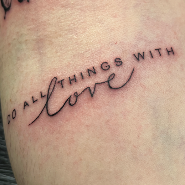 Fineline tekst tattoo met de quote 'DO ALL THINGS WITH love'.