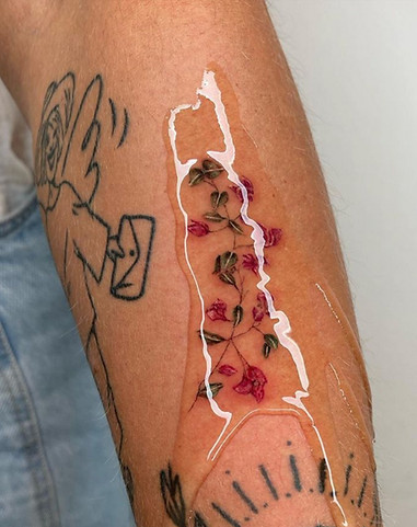 Realistische roze bougainvillea tak tattoo op onderarm.