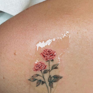 Kleine realistische tattoo van twee rozen op schouder