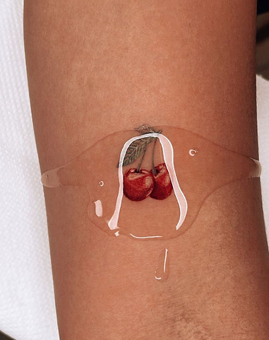 Realistische kersen onder een laagje druipend water op de arm.