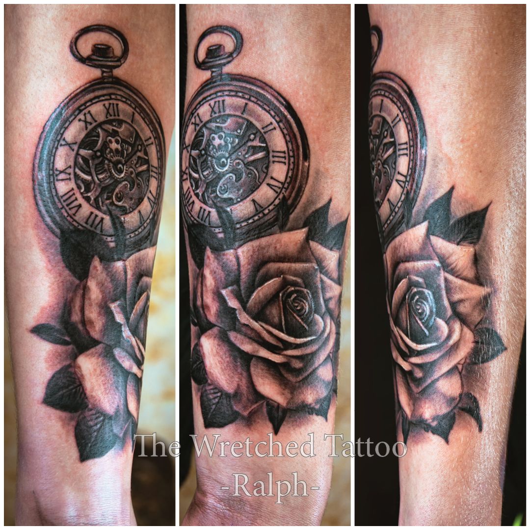 Realistische zwart-wit tattoo van een zakhorloge en een roos op de onderarm.